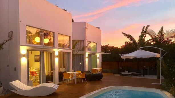 A modern house with a swimming pool, outdoor seating, and a covered patio area. - No1 Stylish Beach House With Pool (Florianópolis)