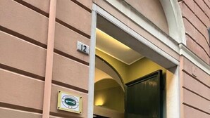 A hotel entrance with a green door, a checkered floor, and a number '12' sign. - Genova Gold Rooms (Genoa)