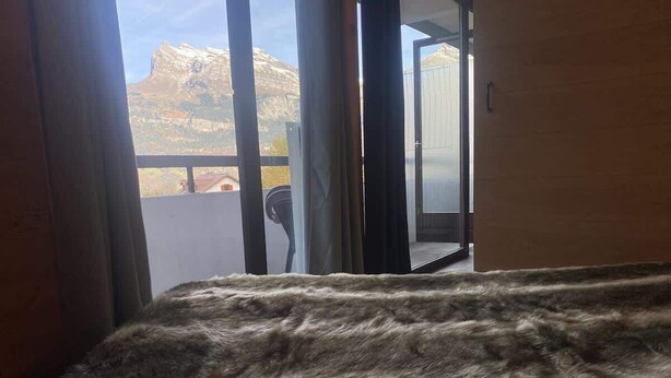 A room with a view of mountains through a sliding door. - Avalon Central 1 Bed Apartment by Tram Station (Saint-Gervais-les-Bains)