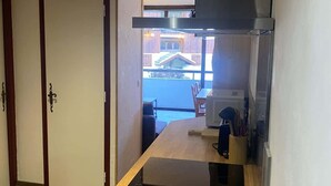 A modern kitchen with a wooden countertop, a built-in stove, and a view of the outside. - Avalon Central 1 Bed Apartment by Tram Station (Saint-Gervais-les-Bains)