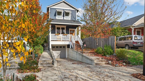 A two-story house with a front porch, a garage, and a driveway. - St. Johns Nest, Near Cathedral Park (Portland)