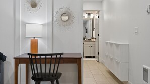 A modern kitchen with white cabinets, a wooden table, and a black chair. - St. Johns Nest, Near Cathedral Park (Portland)