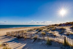 A beach with a wooden fence, sandy dunes, and the ocean. - Cozy Studio with Private Terrace – Ideal for a Seaside Getaway (Cap d'Agde)