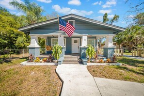 A residential house with a front porch, an American flag, and a mailbox.