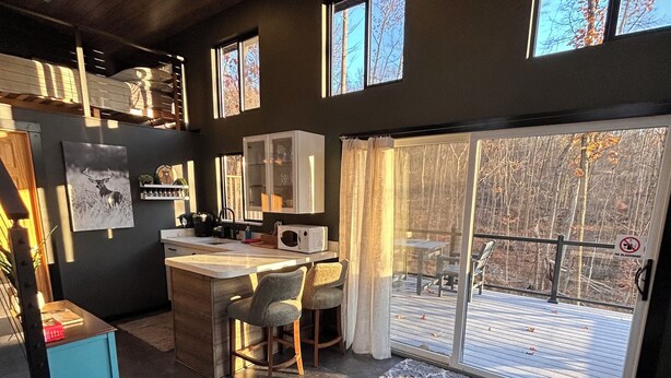 Una cocina moderna con comedor, ventanas amplias y vistas al exterior.