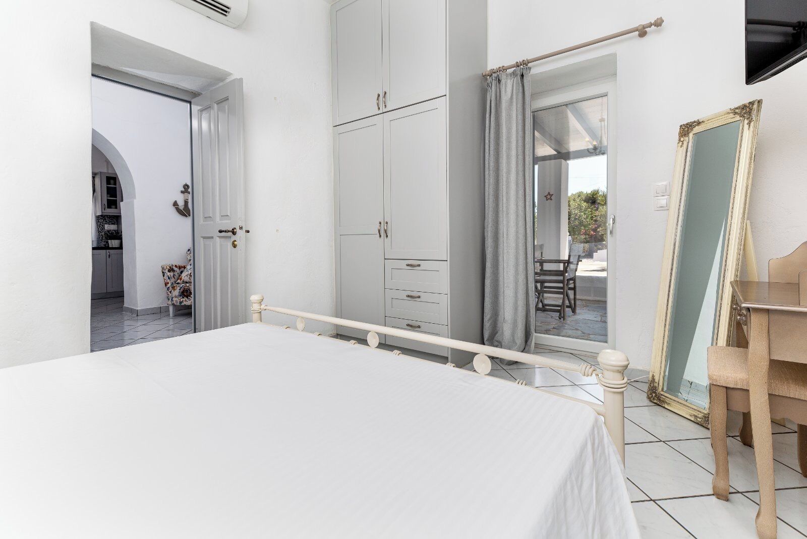 Een slaapkamer met een bed, een kledingkast en een spiegel.