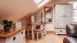A cozy attic bedroom with a wooden desk, a vanity, a large wardrobe, and a leather chair. - Ellenboro House, Cosy Sleeps 2, Near Cartmel (Newton-in-Cartmel)