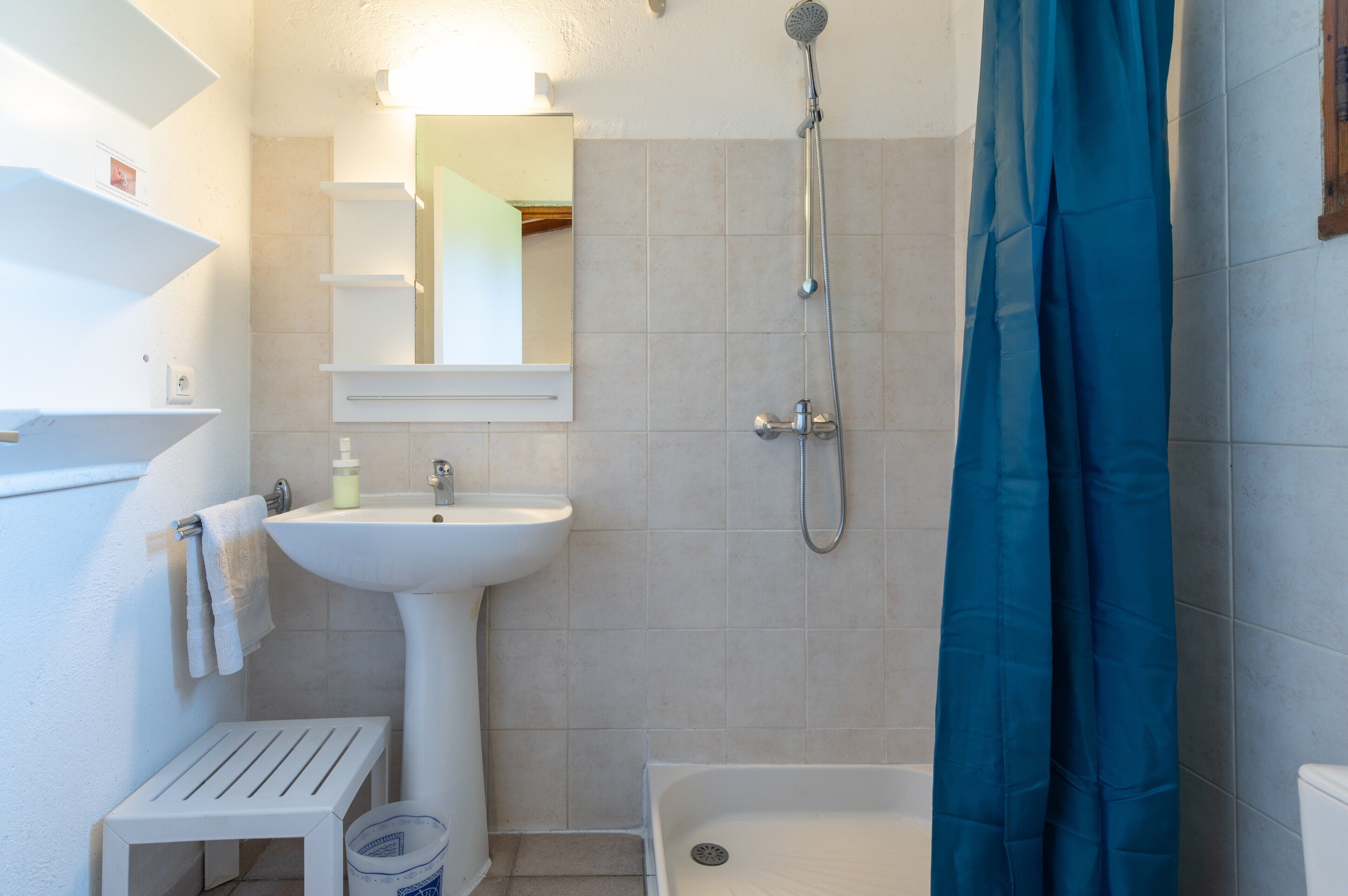 Un baño con lavamanos, espejo, ducha y bañera.