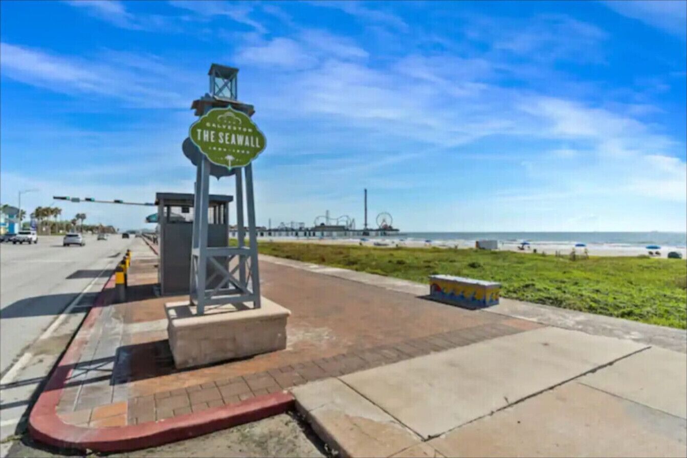 Une promenade en bord de mer avec un panneau indiquant : « Le rempart maritime ».