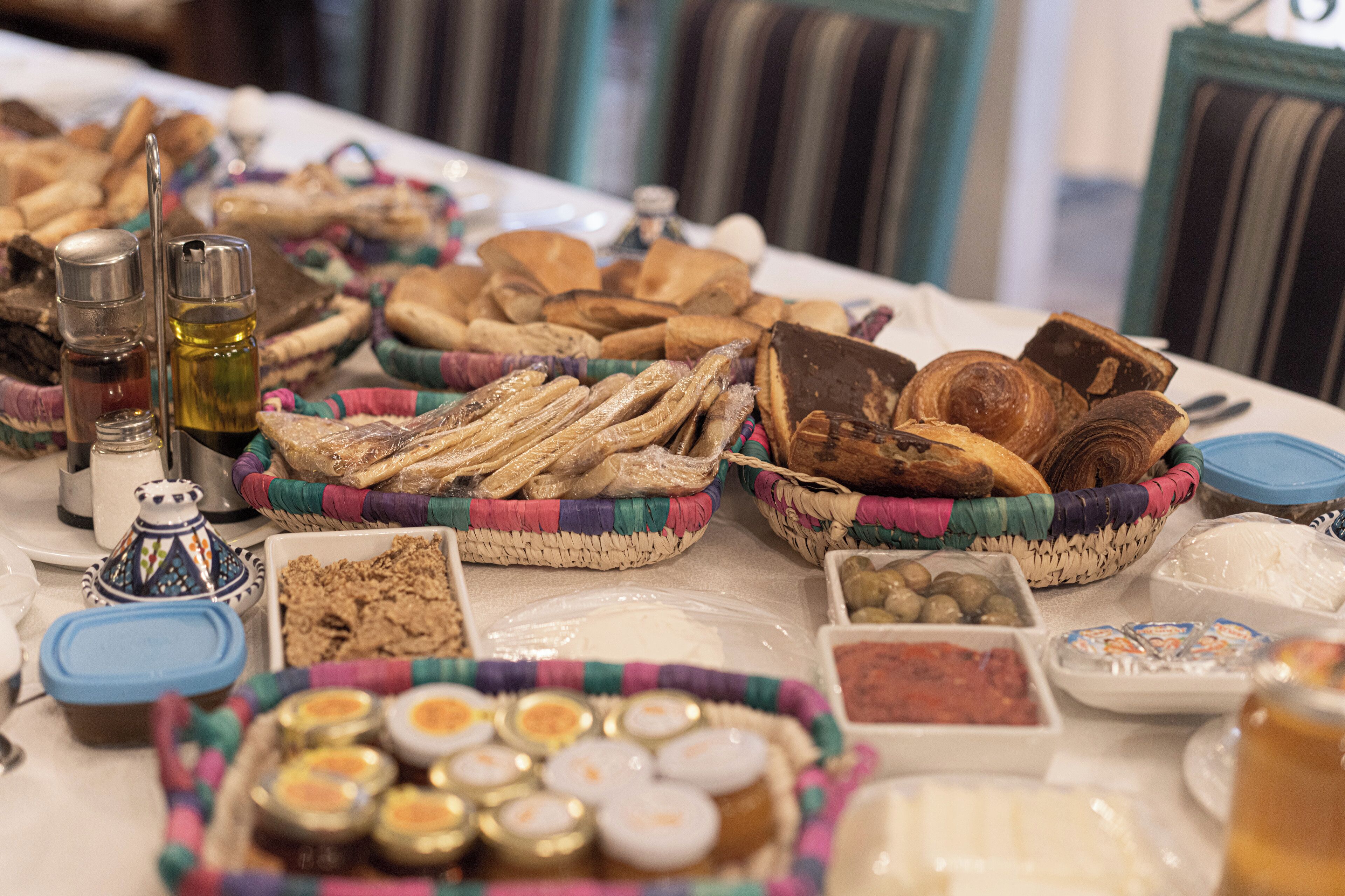 A table with various food items including breads, cheeses, and condiments.