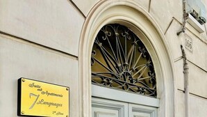 A building entrance with a sign indicating 'Suite and Apartments 7 Languages 2nd Floor'. - Vacanze Romane Suite 7 Languages (Rome)