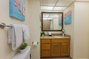 A bathroom with a sink, mirror, towel rack, and a potted plant. - Ocean View One Bedroom Kaanapali Shores 826 (Lahaina)