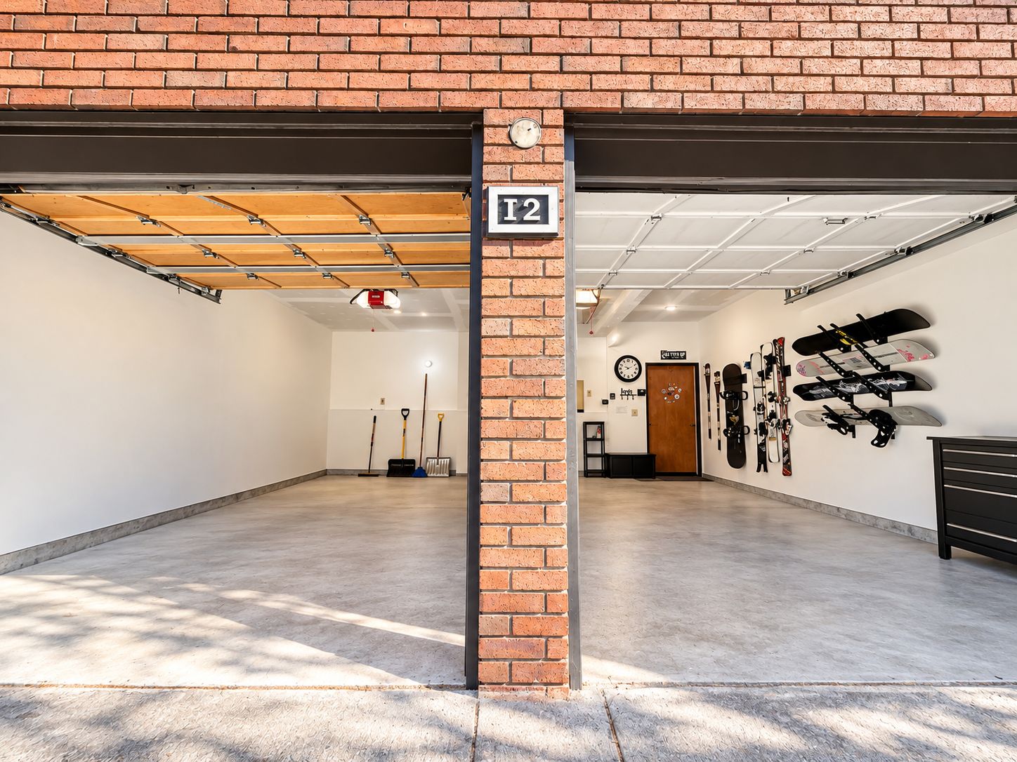 A spacious indoor parking garage with a brick wall, a ceiling with exposed beams, and a sign indicating the garage number.