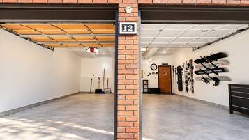 A spacious indoor parking garage with a brick wall, a ceiling with exposed beams, and a sign indicating the garage number.