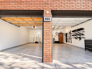A spacious indoor parking garage with a brick wall, a ceiling with exposed beams, and a sign indicating the garage number.