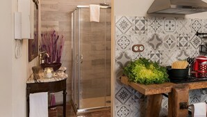 A bathroom with a glass shower enclosure, a sink with a marble countertop, and a tiled backsplash with geometric patterns. - L'Escala-Ventalló. Cosy, WiFi & Rooftop terrace EG (Ventalló)