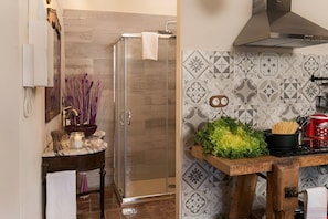 A bathroom with a glass shower enclosure, a sink with a marble countertop, and a tiled backsplash with geometric patterns. - L'Escala-Ventalló. Cosy, WiFi & Rooftop terrace EG (Ventalló)