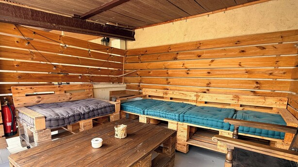 Une cabane en bois rustique, équipée de deux lits, d’une table et d’un extincteur.