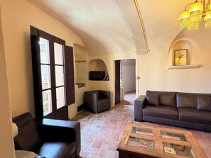 A living room with a sofa, armchair, and coffee table. - Ventalló/L'Escala. WiFi. Rooftop w/ stunning views (Ventalló)