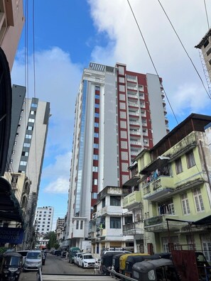 Un immeuble à plusieurs étages doté d’une façade moderne, agrémentée de balcons et présentant un mélange de styles architecturaux.