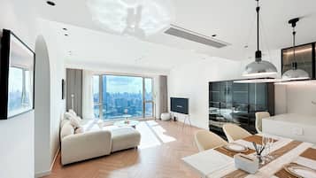 Suite familiare, 2 camere da letto, vista città | Area soggiorno | TV