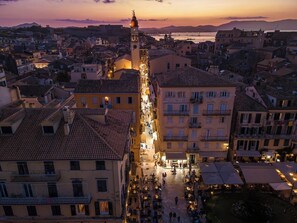 A historic town square with a prominent clock tower, surrounded by traditional buildings and a waterfront view. - Royal View Suite - Corfu Town (Corfu)