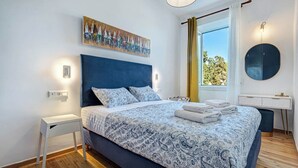 A bedroom with a bed, bedside table, and a painting on the wall. - Royal View Suite - Corfu Town (Corfu)