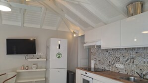 A modern kitchen with white cabinetry, a marble countertop, a built-in oven, and a patterned backsplash. - The Colibri, Orient Bay, Private Jacuzzi (ST MARTIN)