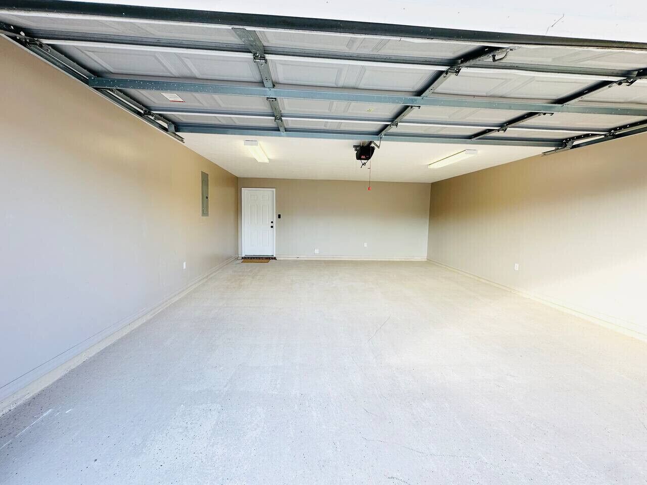 Eine geräumige Garage mit Betonboden und einer Metalldoortür.