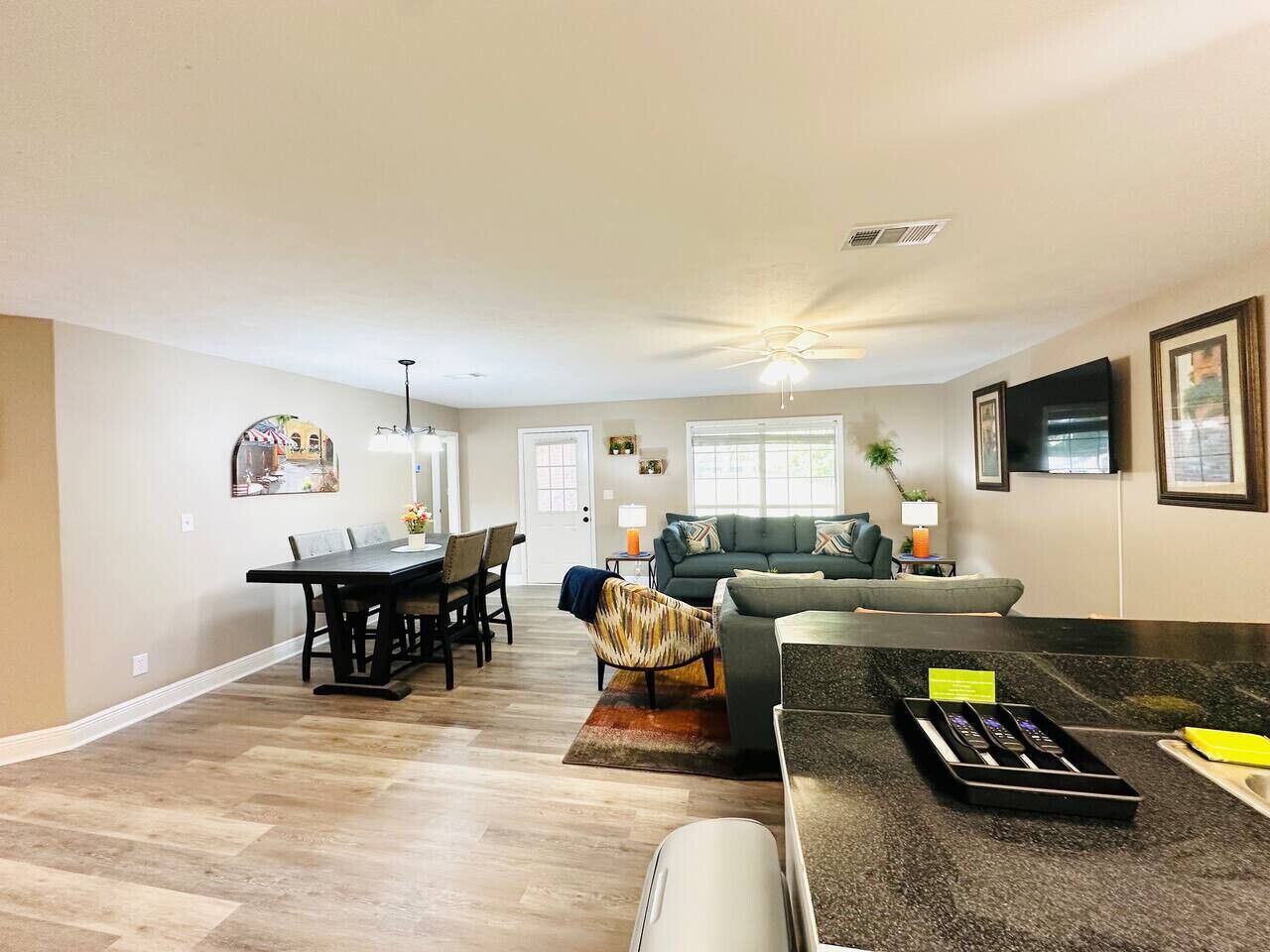 A spacious living area with a dining table, a sofa, and a kitchen counter.