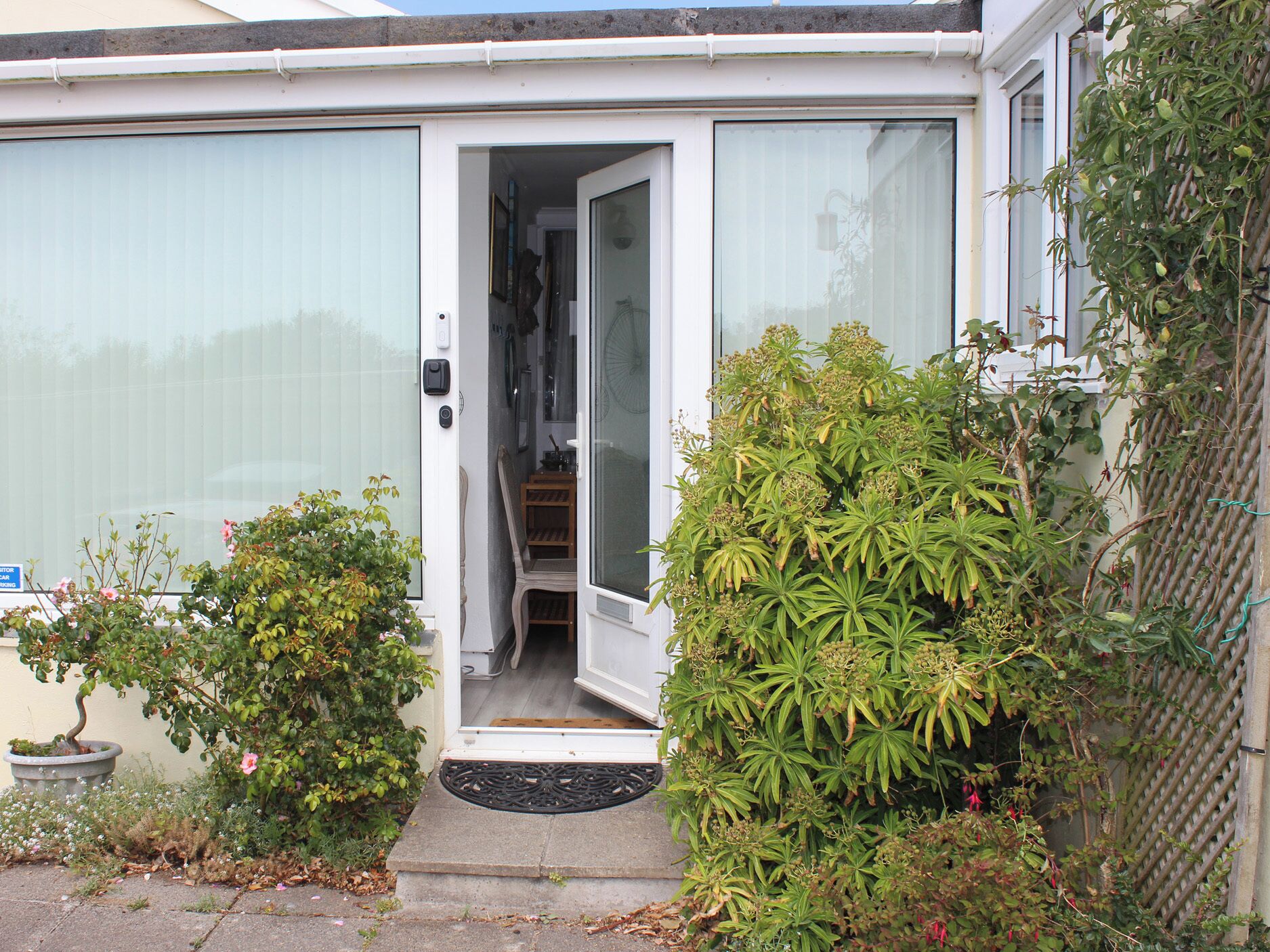 A residential house with a door leading to a staircase and a small porch area.