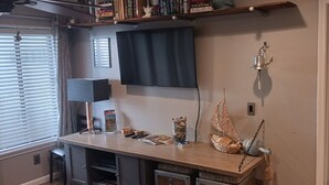 A room with a desk, a lamp, a bookshelf, a window with blinds, and a door. - 2-bedroom condo in wonderful Isle of Palms with AC
Beach and Pier access (Isle of Palms)