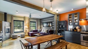A modern kitchen with a dining area, wooden flooring, and a large window. - Bavarian Chalet - Ski-In Ski-Out Taos Ski Valley (Taos Ski Valley)