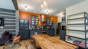 A modern kitchen with a wooden dining table, built-in cabinets, and a bookshelf. - Bavarian Chalet - Ski-In Ski-Out Taos Ski Valley (Taos Ski Valley)