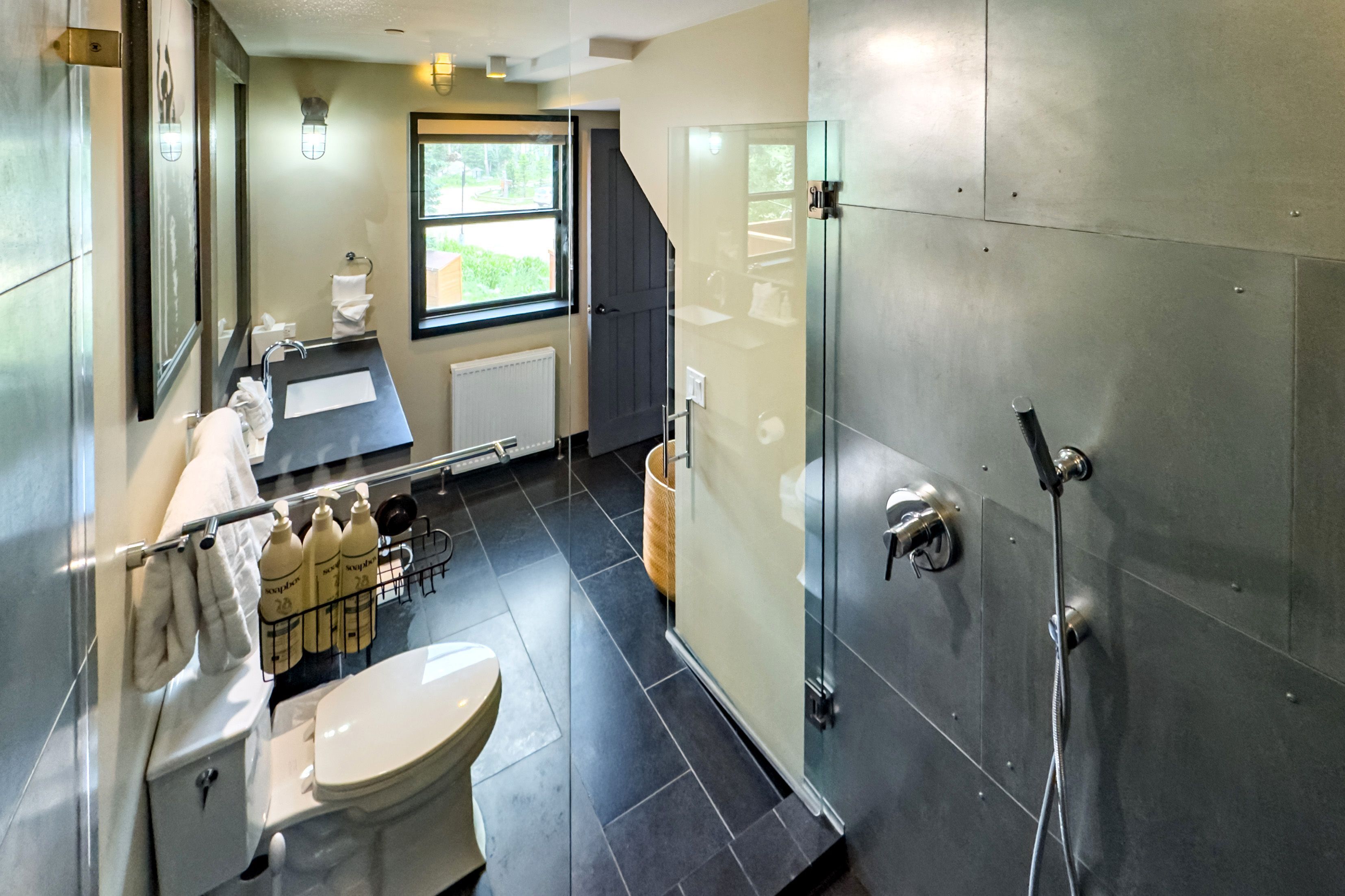 A modern bathroom with a toilet, sink, and shower.