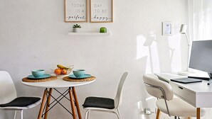 A modern, well-lit room with a dining table, chairs, and a desk with a computer. There are two framed inspirational quotes on the wall, a small plant on a shelf, and a window with curtains. - Apt Tamarells Pinaret 350m to the beach. By JS Vil (Puerto Pollensa)