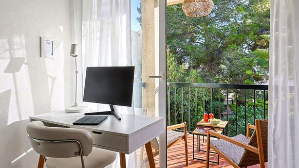 A modern room with a desk, chair, and a balcony with outdoor furniture. - Apt Tamarells Pinaret 350m to the beach. By JS Vil (Puerto Pollensa)