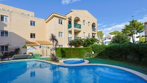 A swimming pool surrounded by a well-maintained garden and a multi-story building with balconies. - Apt Tamarells Pinaret 350m to the beach. By JS Vil (Puerto Pollensa)