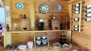 A wooden interior with shelves displaying plates, bowls, and a wine rack. - Zeta Camping (Juta)
