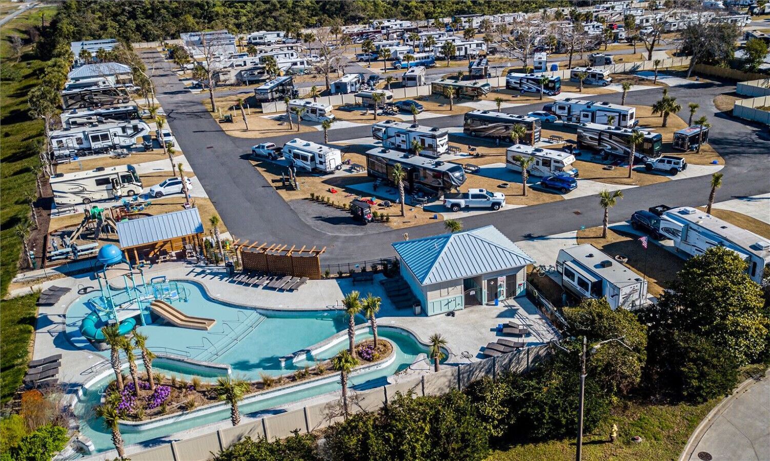 Un terrain de camping pour véhicules récréatifs doté d’une piscine et d’un petit bâtiment.