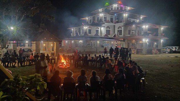 Un edificio grande de varios pisos con un patio central que tiene una chimenea.