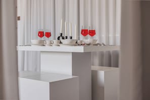 A white table with red wine glasses, white cups, and black candle holders. - Elegant Stay with Burj Khalifa View (Dubai)