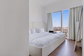 A modern hotel room with a large bed, a city view, and a minimalist design. - Elegant Stay with Burj Khalifa View (Dubai)