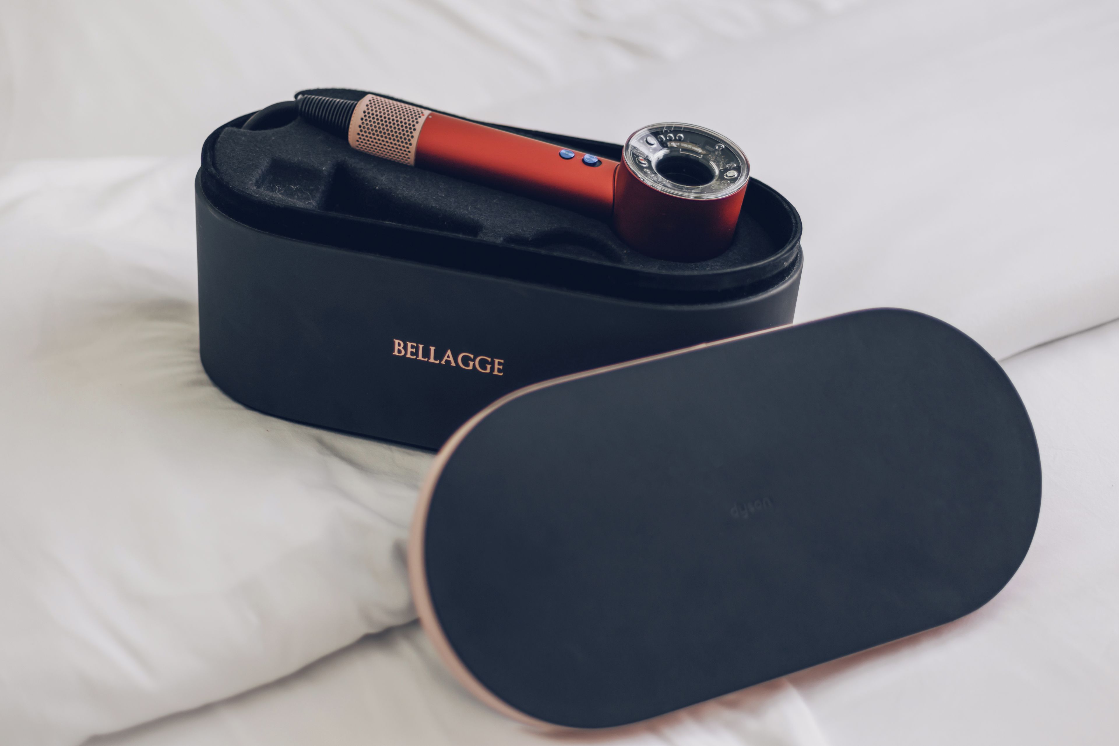 A black case with a device and a separate black object on a white surface.