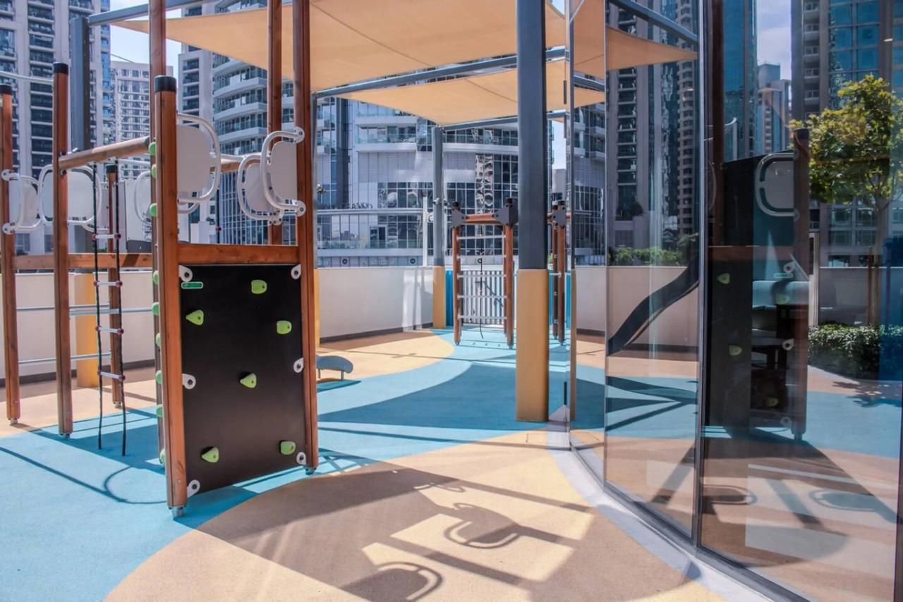 Um espaço infantil coberto com estruturas de escalada e área de recreação macia.