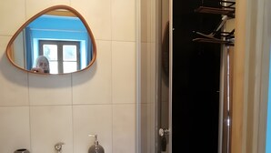A bathroom with a white vanity, a round mirror, and a glass-enclosed shower. - Bed and Breakfast 'Le Myosotis' with Shared Terrace, Wi-Fi and Air Conditioning (Rehaupal)