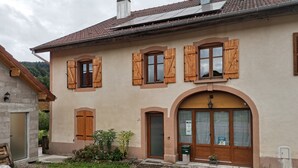 A two-story house with wooden shutters, a stone facade, and a gravel driveway. - Bed and Breakfast 'Le Myosotis' with Shared Terrace, Wi-Fi and Air Conditioning (Rehaupal)