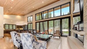 A spacious living room with a large sofa, a coffee table, and a fireplace. - The Colony at White Pine Canyon by KBM (Park City)