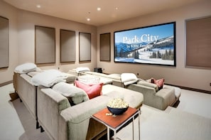 Un cine en casa con una pantalla grande mostrando 'Park City by KBM Resorts'.