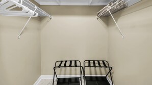 Een kamer met twee zwarte metalen stoelen, een dakvenster en witte plafondventilatoren.